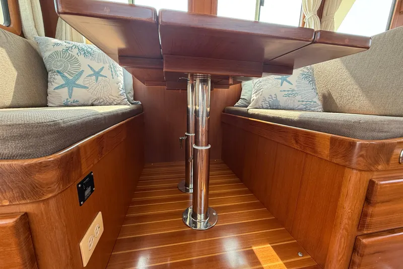 Raven Song Yacht Photos Pics Interior of 2011 North Pacific 38 Sedan with wooden table and cushioned seating.