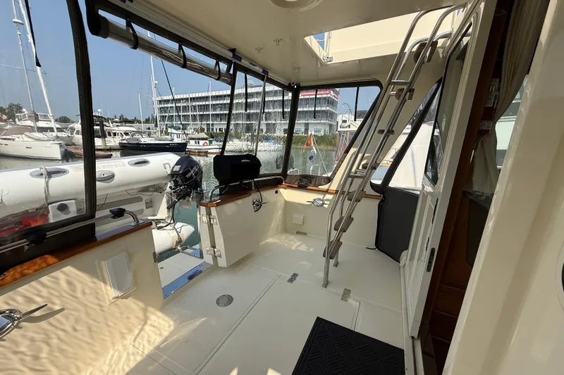 Raven Song Yacht Photos Pics 2011 North Pacific 38 Sedan interior with marina view, featuring ladder and enclosed deck area.