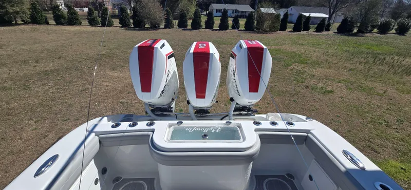  Yacht Photos Pics 2017 Yellowfin 36 boat with three powerful outboard engines, parked on grassy area.