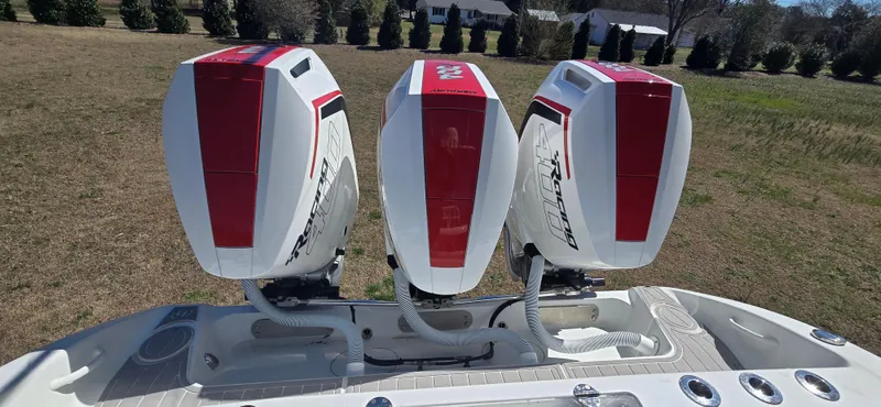  Yacht Photos Pics Triple outboard motors on a 2017 Yellowfin 36 boat, parked on grass.