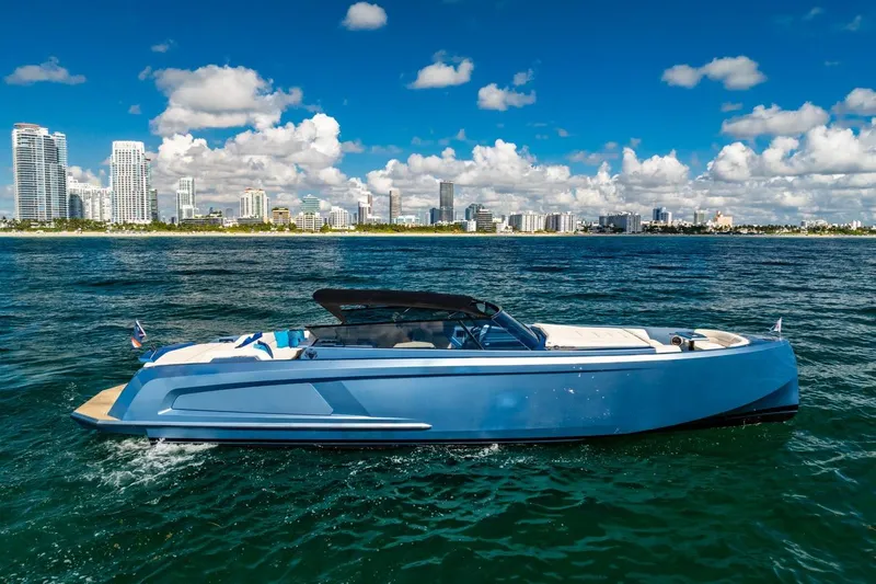 Impulsive Yacht Photos Pics 2019 Vanquish Yachts VQ58 cruising near a city skyline under a blue sky.