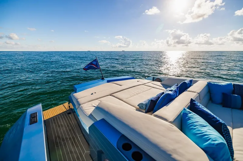 Impulsive Yacht Photos Pics Luxurious 2019 Vanquish Yachts VQ58 on open sea with sunlit deck and cushions.