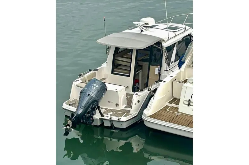  Yacht Photos Pics 2025 Cutwater C-248 Coupe boat docked with outboard motor in calm water.