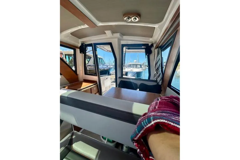  Yacht Photos Pics Interior view of 2025 Cutwater C-248 Coupe boat, showcasing seating and windows.