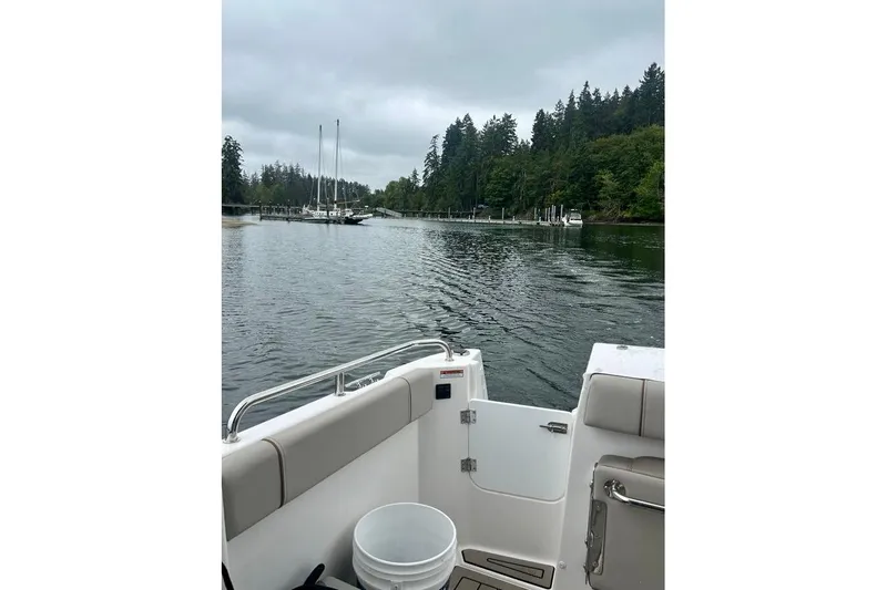  Yacht Photos Pics 2025 Cutwater C-248 Coupe on a serene lake with forested shoreline.