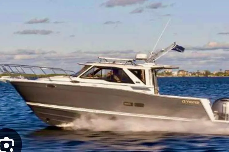  Yacht Photos Pics 2025 Cutwater C-248 Coupe cruising on open water under a partly cloudy sky.