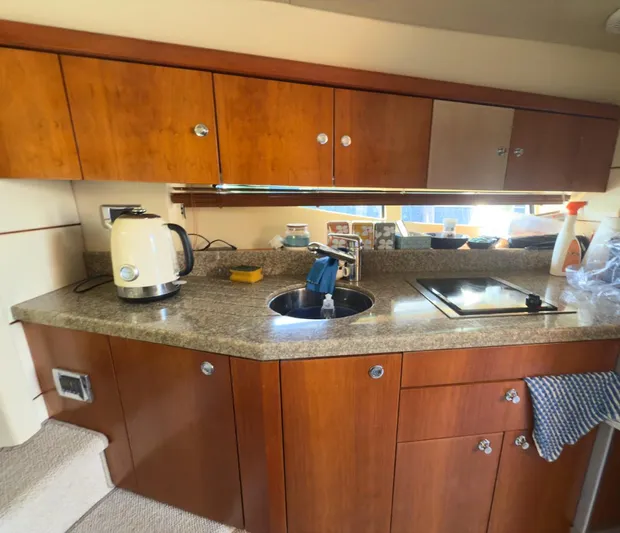  Yacht Photos Pics Luxurious 2007 Sunseeker Superhawk 43 yacht kitchen with wooden cabinets and modern appliances.