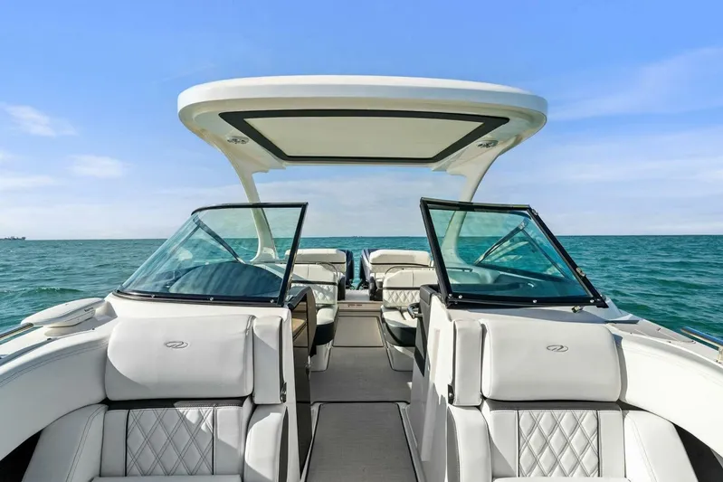  Yacht Photos Pics 2023 Regal 29 OBX boat interior with open seating, cruising on a clear blue sea.