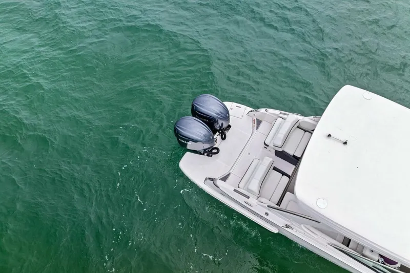  Yacht Photos Pics 2023 Regal 29 OBX boat with dual outboard motors on green water.