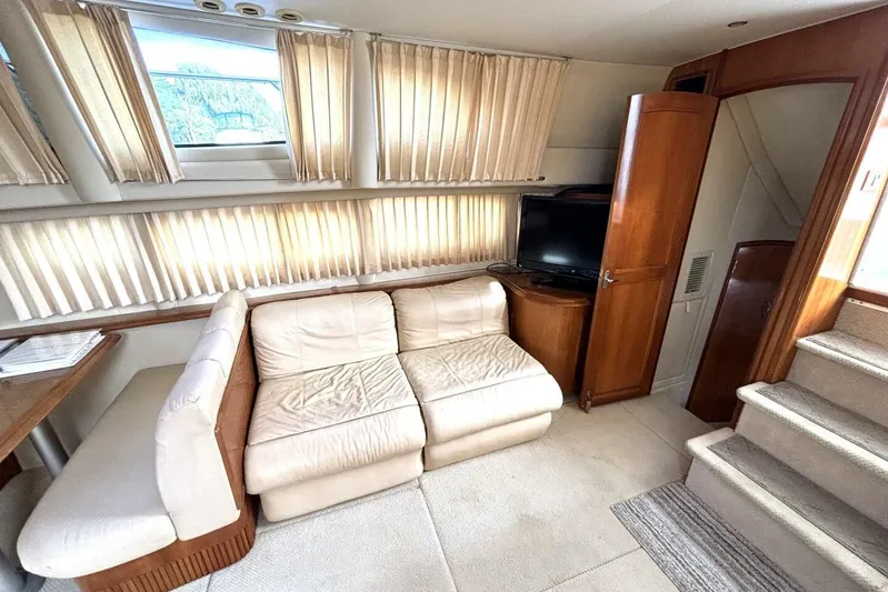  Yacht Photos Pics 2003 Carver 396 Motor Yacht interior with cream sofa, TV, and wooden cabinetry.