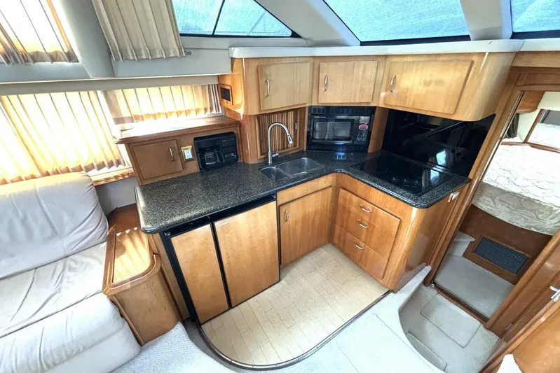  Yacht Photos Pics 2003 Carver 396 Motor Yacht interior kitchen with wood cabinetry and modern appliances.