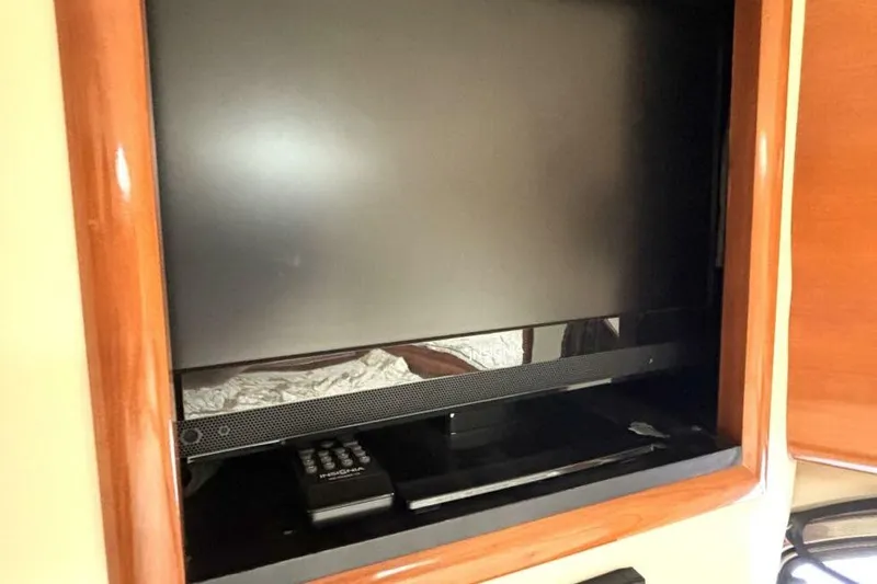  Yacht Photos Pics Flat-screen TV and remote in 2003 Carver 396 Motor Yacht interior.