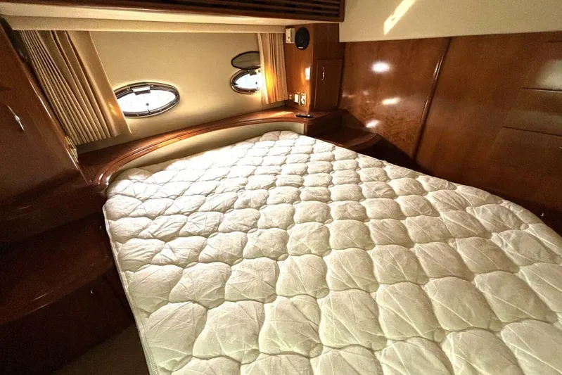  Yacht Photos Pics Luxurious bedroom interior of 2003 Carver 396 Motor Yacht with plush bedding and porthole windows.