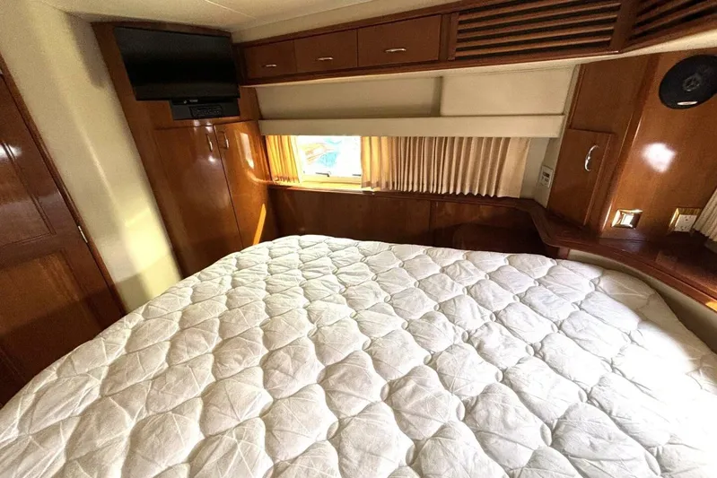  Yacht Photos Pics Luxurious bedroom interior of 2003 Carver 396 Motor Yacht with wood accents and cozy bedding.