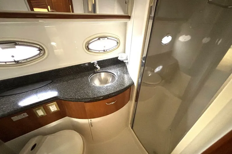  Yacht Photos Pics Luxurious bathroom in 2003 Carver 396 Motor Yacht with modern fixtures and porthole windows.
