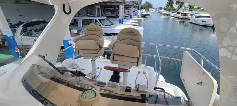  Yacht Photos Pics 2004 Sea Ray 480 Sedan Bridge yacht helm with dual captain chairs docked at marina.