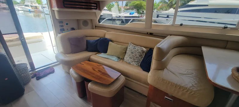  Yacht Photos Pics Luxurious interior of a 2004 Sea Ray 480 Sedan Bridge yacht with plush seating and wooden table.