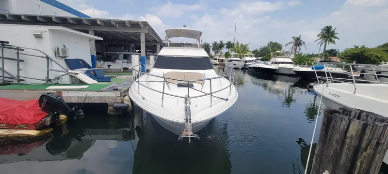  Yacht Photos Pics 2004 Sea Ray 480 Sedan Bridge docked at a marina with other boats.