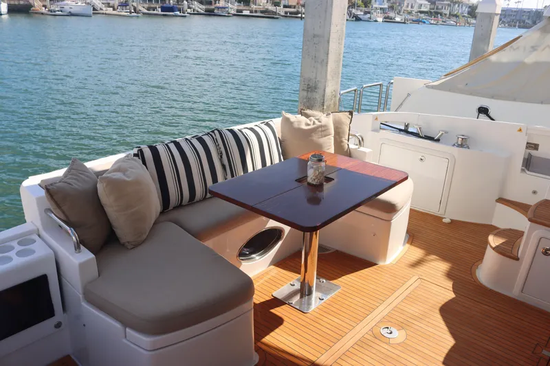  Yacht Photos Pics Luxurious 2015 Azimut 54 Fly yacht deck with seating and table, overlooking marina.