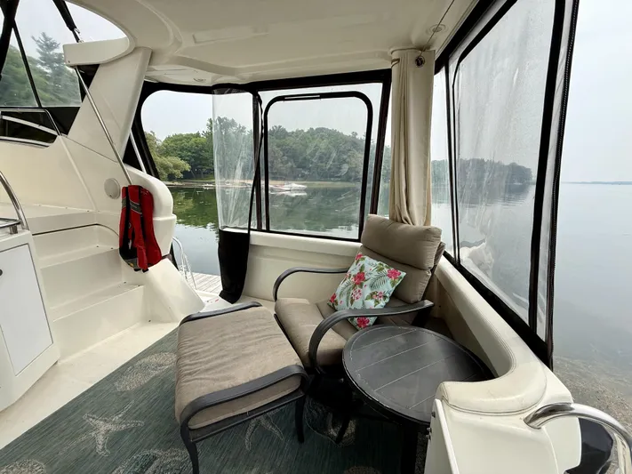  Yacht Photos Pics 1997 Silverton 402 Motor Yacht interior with cozy seating, table, and scenic lake view.