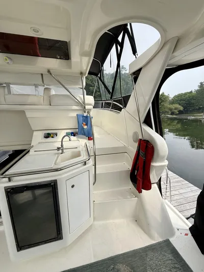  Yacht Photos Pics 1997 Silverton 402 Motor Yacht interior with kitchenette and stairs, docked by a serene lake.
