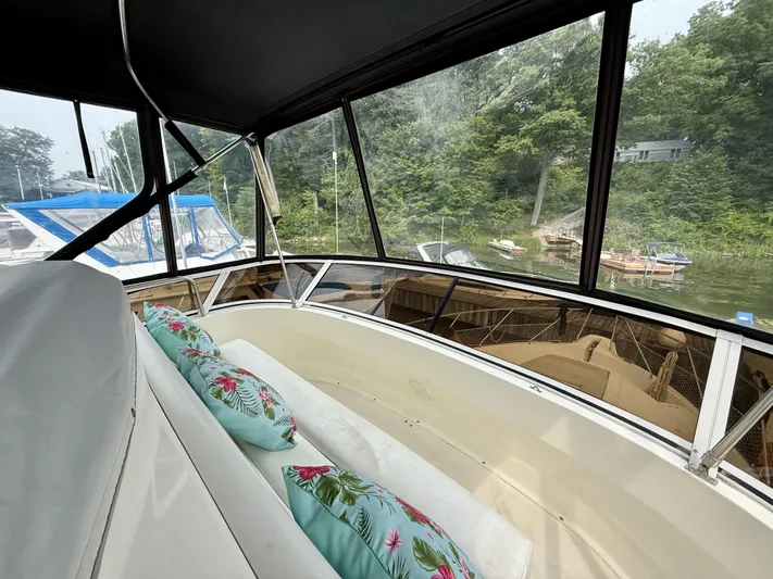  Yacht Photos Pics 1997 Silverton 402 Motor Yacht interior with floral cushions, docked near lush greenery.