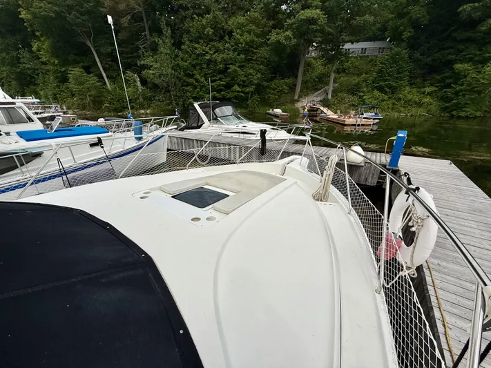 Yacht Photos Pics 1997 Silverton 402 Motor Yacht docked at a marina with surrounding boats and lush greenery.