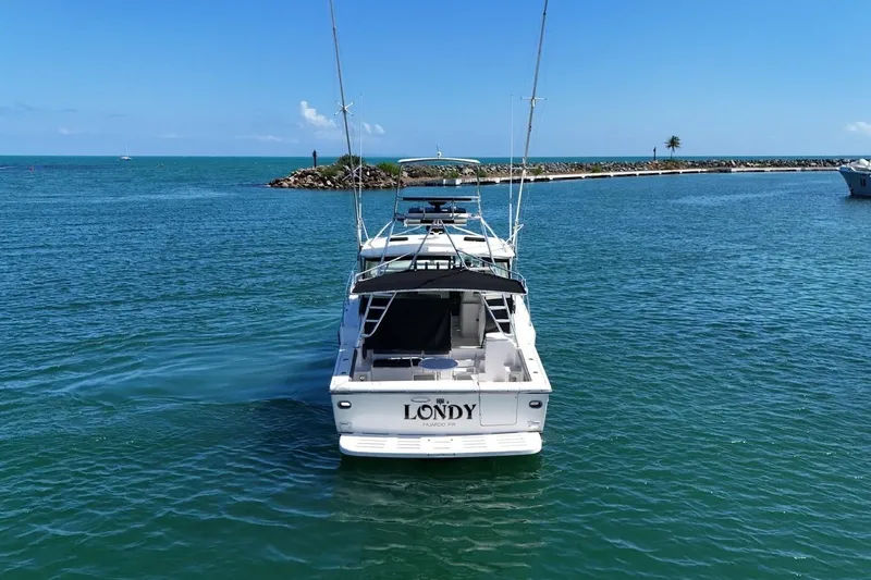  Yacht Photos Pics 1999 Tiara Yachts 4100 Open cruising in clear blue waters near a rocky shoreline.