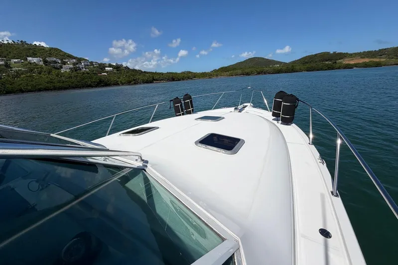  Yacht Photos Pics 1999 Tiara Yachts 4100 Open cruising on a scenic lake with lush hills.