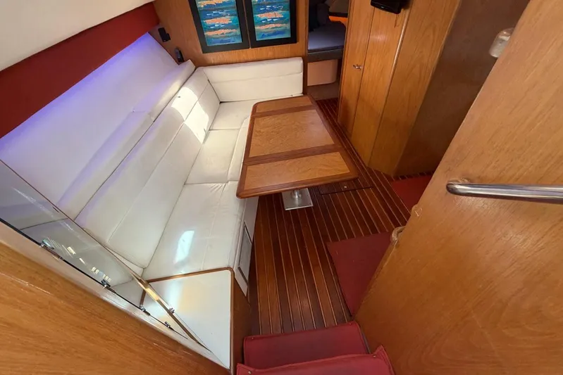  Yacht Photos Pics 1999 Tiara Yachts 4100 Open interior with white seating and wooden table.