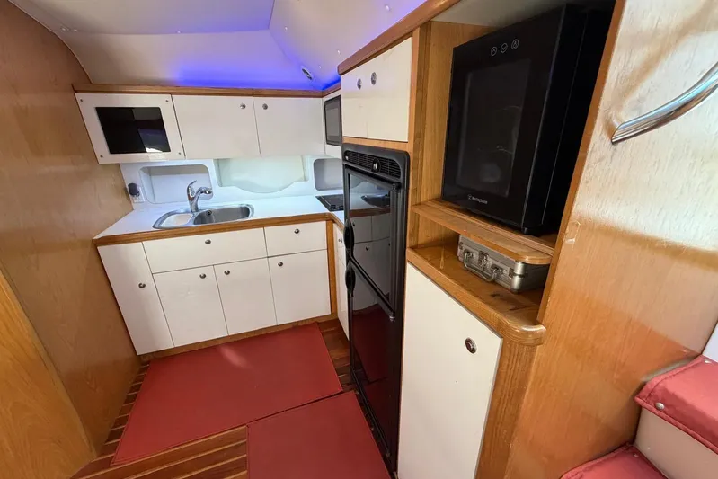 Yacht Photos Pics 1999 Tiara Yachts 4100 Open interior kitchen with wood cabinetry and modern appliances.