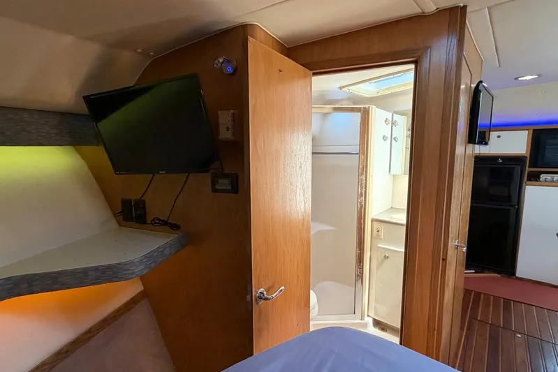  Yacht Photos Pics 1999 Tiara Yachts 4100 Open interior with TV, wooden cabinetry, and bathroom view.