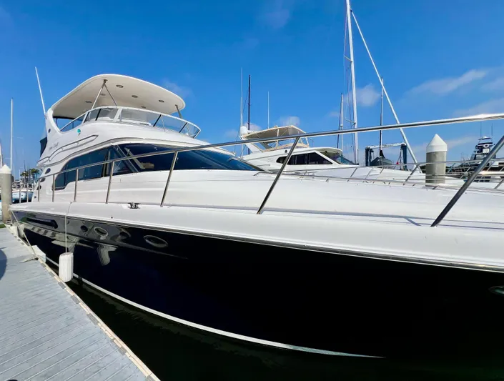 Bella Jolie Yacht Photos Pics 2002 Sea Ray 560 Sedan Bridge yacht docked at marina under clear blue sky.