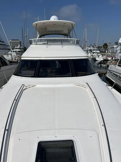 Bella Jolie Yacht Photos Pics 2002 Sea Ray 560 Sedan Bridge yacht docked in a marina under clear blue skies.