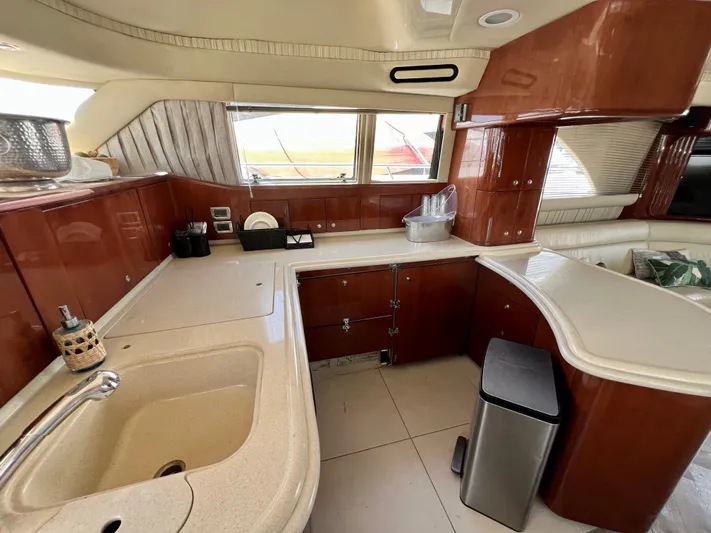 Bella Jolie Yacht Photos Pics Luxurious kitchen interior of 2002 Sea Ray 560 Sedan Bridge yacht with wood cabinetry.