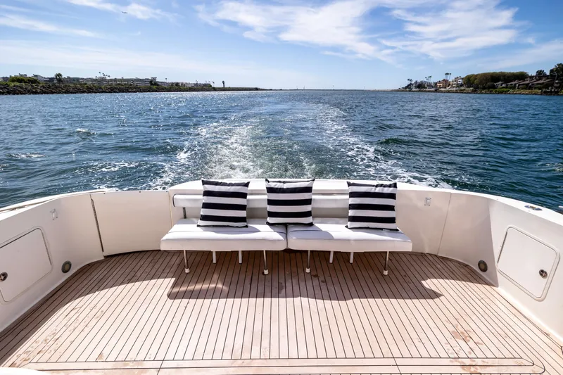 Bella Jolie Yacht Photos Pics Rear view of 2002 Sea Ray 560 Sedan Bridge yacht with striped cushions on deck.