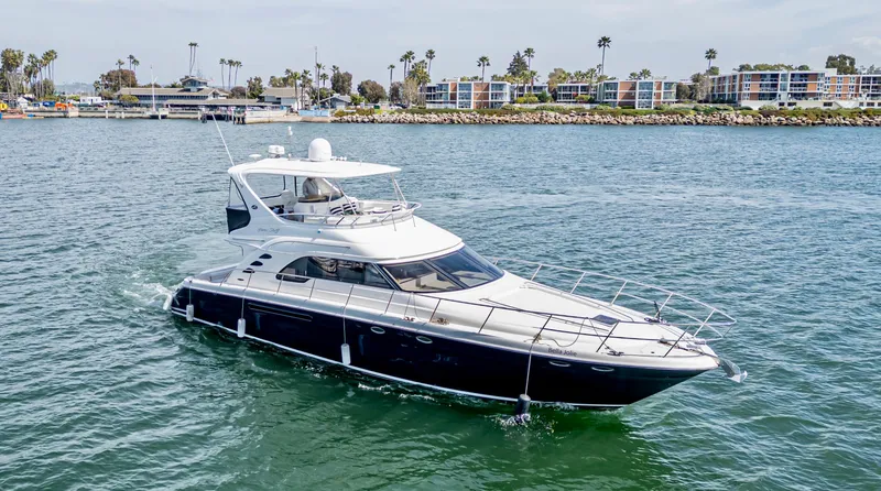 Bella Jolie Yacht Photos Pics 2002 Sea Ray 560 Sedan Bridge yacht cruising in a scenic harbor.
