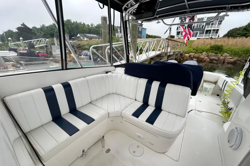  Yacht Photos Pics 2003 Intrepid 310 Walkaround boat with white and navy seating, docked near a marina.
