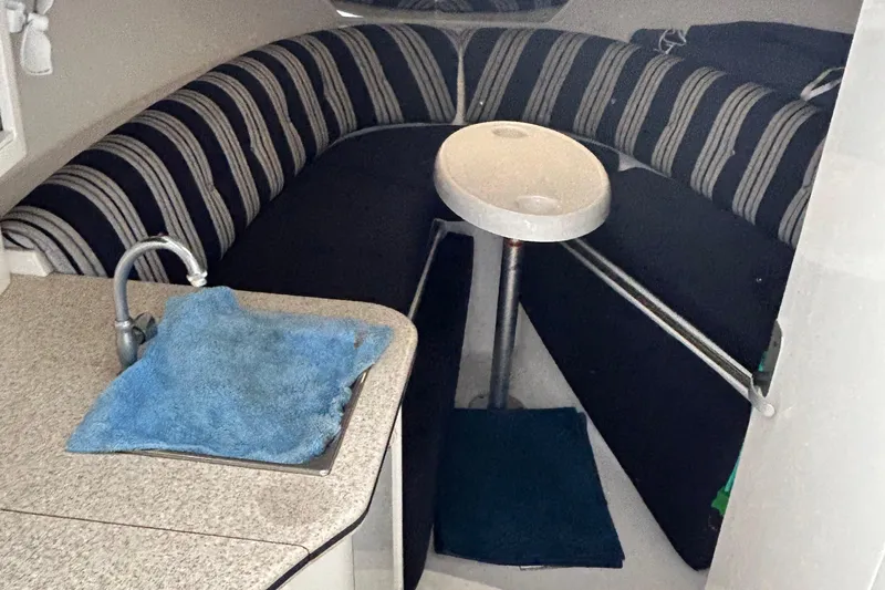  Yacht Photos Pics Interior of 2003 Intrepid 310 Walkaround with striped seating and compact kitchenette.