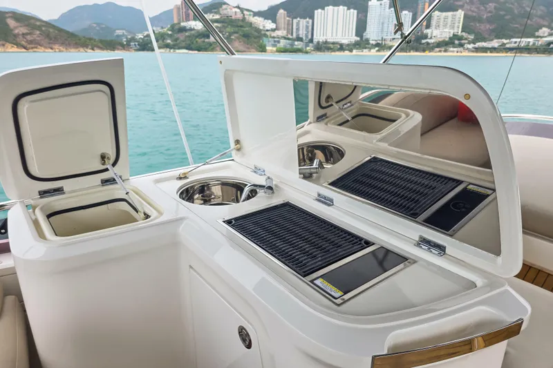  Yacht Photos Pics Outdoor kitchen on 2019 Princess F45 yacht with grill and sink, overlooking scenic waterfront.