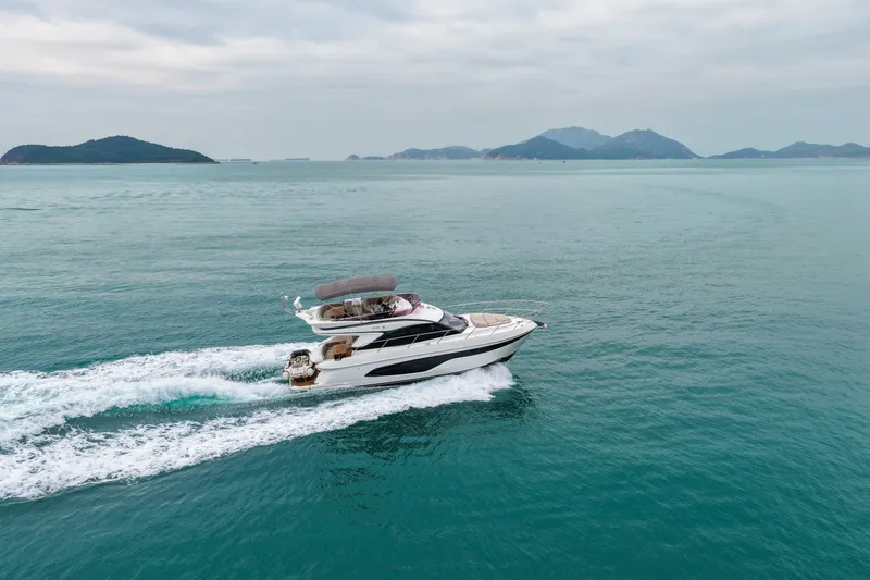  Yacht Photos Pics Luxurious 2019 Princess F45 yacht cruising on open sea with scenic island backdrop.