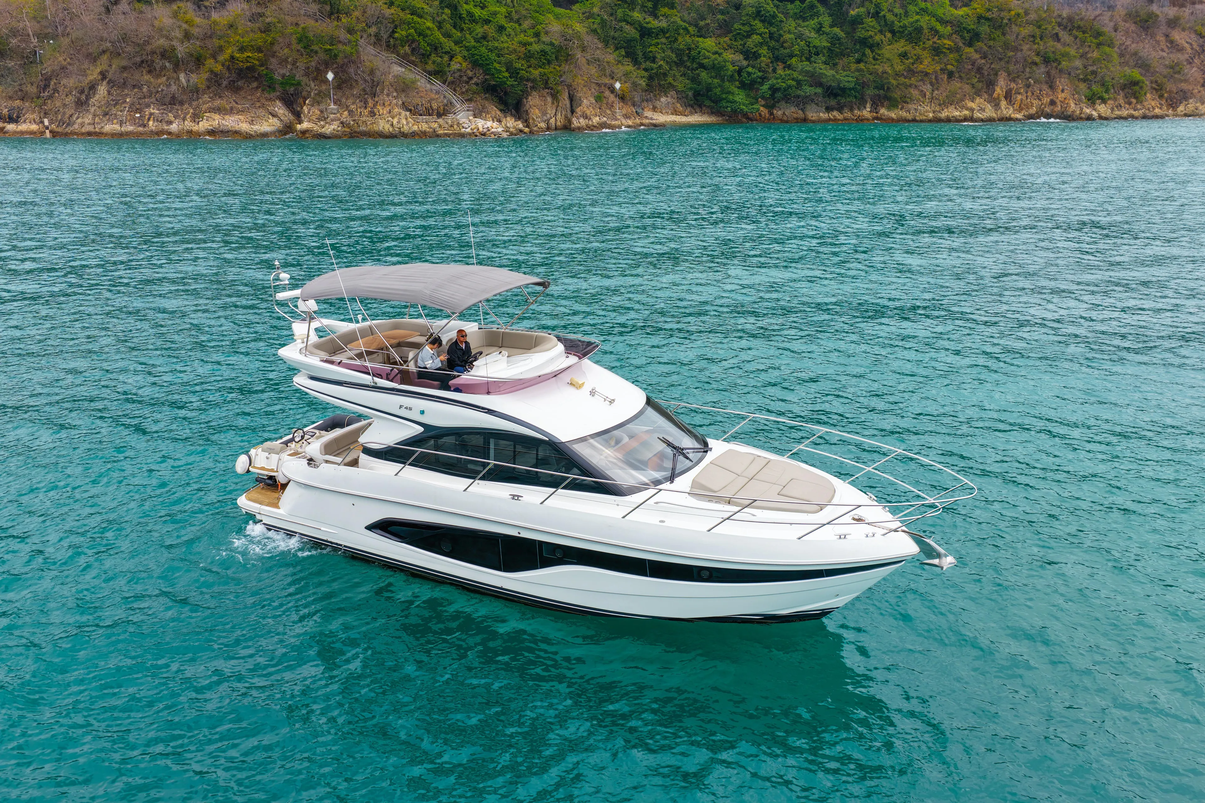  Yacht Photos Pics 2019 Princess F45 yacht cruising on turquoise waters near a lush coastline.