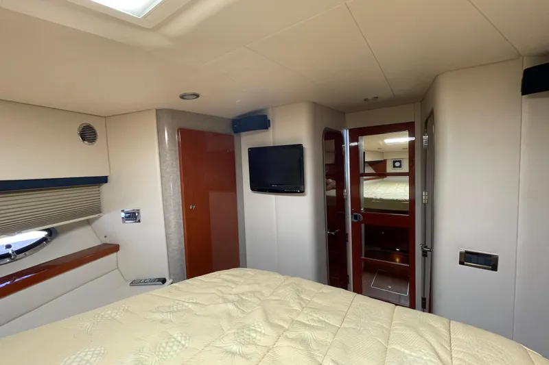  Yacht Photos Pics Interior of 2009 Formula 45 Yacht cabin with bed, TV, and wooden accents.