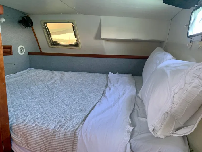 Tranquility Base Yacht Photos Pics Cozy cabin bedroom in 2003 PDQ-34 boat with bed, pillows, and windows.