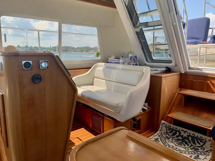 Tranquility Base Yacht Photos Pics Interior of 2003 PDQ-34 boat with white seating, wooden accents, and scenic window view.