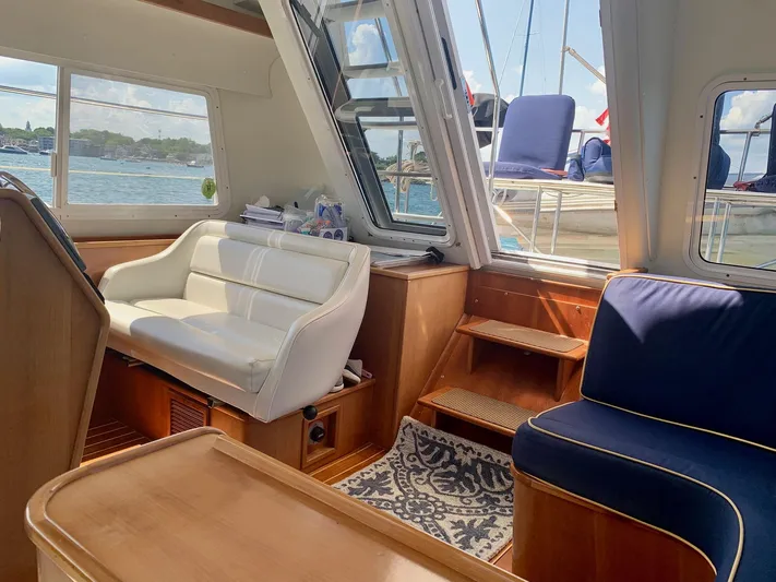 Tranquility Base Yacht Photos Pics Interior of 2003 PDQ-34 boat with white and blue seating, wooden accents, and waterfront view.