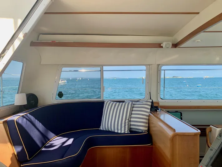 Tranquility Base Yacht Photos Pics Interior of 2003 PDQ-34 boat with blue seating, striped pillows, and ocean view.