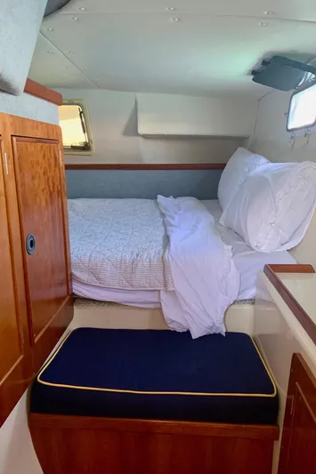 Tranquility Base Yacht Photos Pics Cozy cabin interior of 2003 PDQ-34 boat with bed and wooden cabinetry.