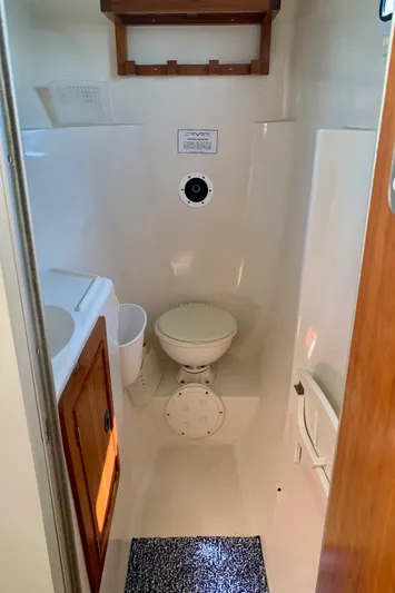 Tranquility Base Yacht Photos Pics Compact marine bathroom in 2003 PDQ-34 boat with toilet, sink, and storage.