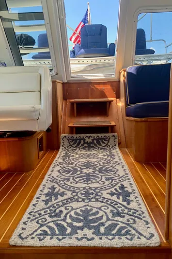 Tranquility Base Yacht Photos Pics Interior of 2003 PDQ-34 boat with elegant rug and seating, American flag visible.